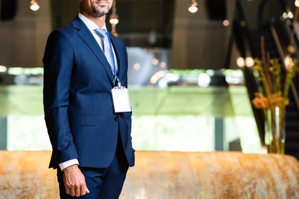 Vista recortada del hombre de negocios en traje con placa en el hotel - foto de stock