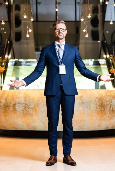 Homem de negócios bonito em terno e óculos com as mãos estendidas — Fotografia de Stock