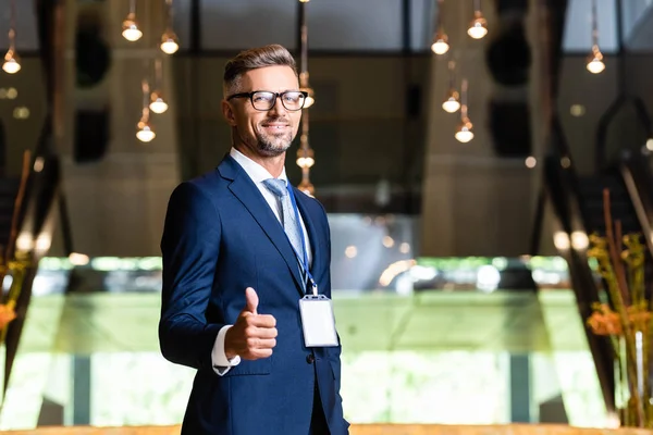 Bel homme d'affaires en costume et lunettes montrant pouce vers le haut — Photo de stock