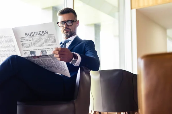 Красивий бізнесмен у костюмі та окулярах читає газетний бізнес — стокове фото