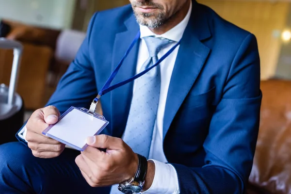 Cropped view of man in formal wear holding badge with copy space — Stock Photo