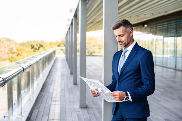 Bonito e confiante empresário em formal desgaste leitura jornal — Fotografia de Stock