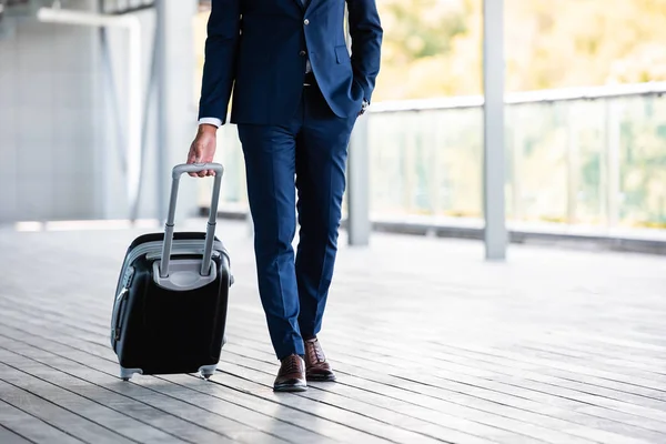 Cropped view of businessman in formal wear holding suitcase — Stock Photo
