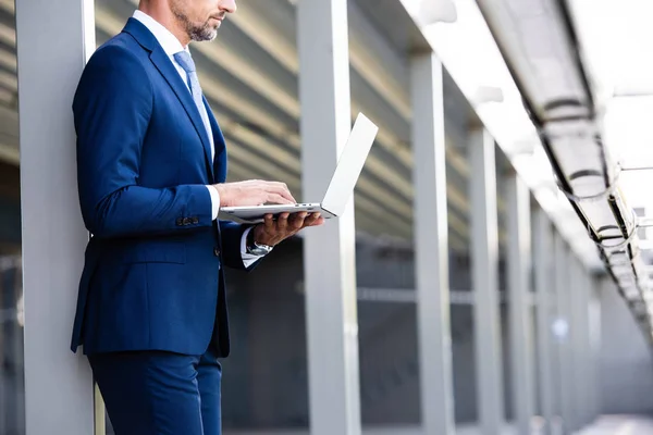 Vista recortada de hombre de negocios en el desgaste formal con el ordenador portátil - foto de stock