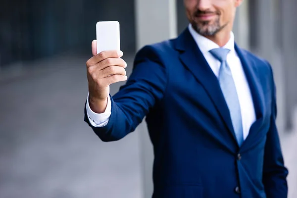 Cropped view of businessman in formal wear talking selfie — Stock Photo