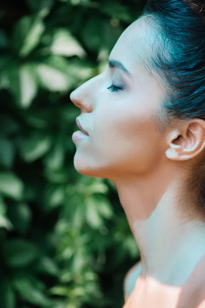 Vista lateral de un rayo azul sobre una joven mujer desnuda con los ojos cerrados - foto de stock