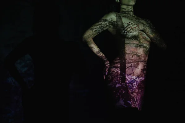 Cropped view of undressed young woman with shadows on body while standing on black — Stock Photo