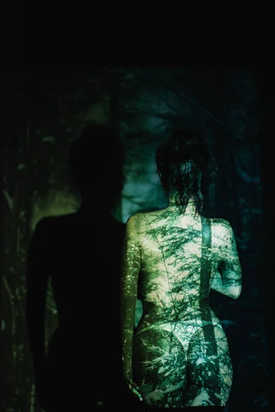 Back view of girl with shadows on body on black — Stock Photo