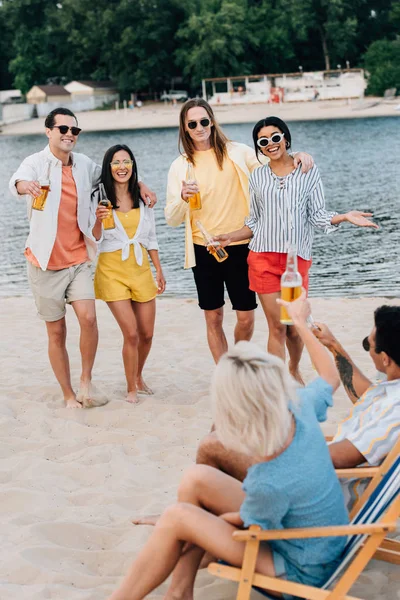 Jovens amigos multiculturais bebendo cerveja e se divertindo na praia — Fotografia de Stock
