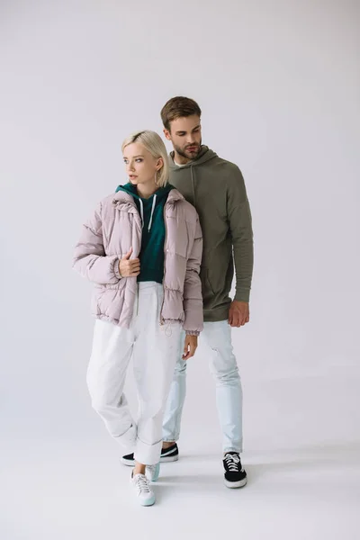 Full length view of stylish blonde girl and bearded man on grey — Stock Photo