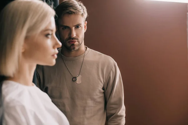 Selective focus of attractive blonde girl and bearded young man on brown — Stock Photo