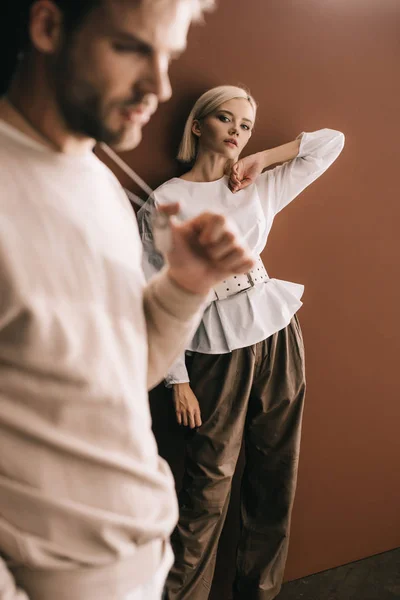Foyer sélectif de jeune homme et fille blonde en chemisier blanc sur brun — Photo de stock