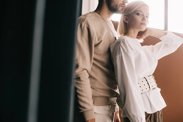 Cropped view of stylish couple standing near curtain — Stock Photo