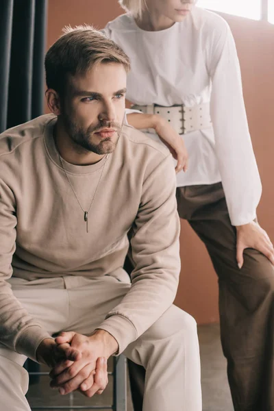 Cropped view of stylish couple near curtain on brown — Stock Photo