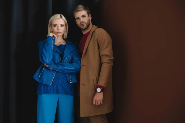 Стильна пара в осінньому вбранні, що стоїть біля завіси — стокове фото