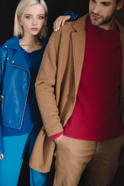 Cropped view of stylish couple in autumn outfits on black — Stock Photo