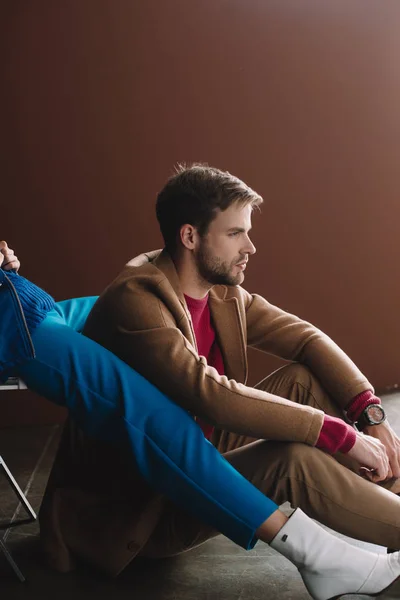 Частковий вид на стильну жінку і чоловіка в осінньому вбранні на коричневому — стокове фото