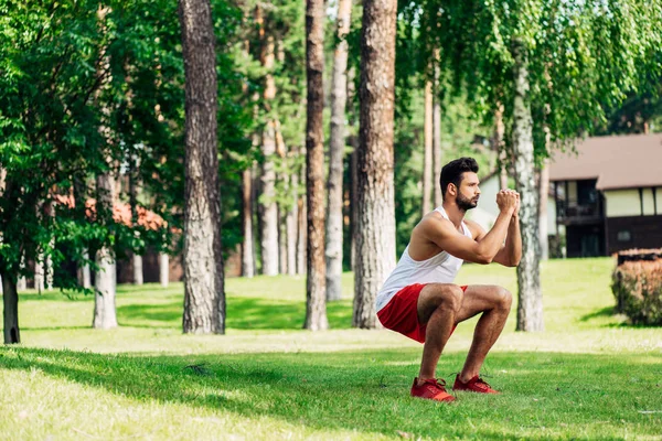 Entraînement sportif barbu dans le parc sur pelouse verte — Stock Photo