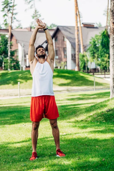 Bearded athletic sportsman training on green lawn — Stock Photo