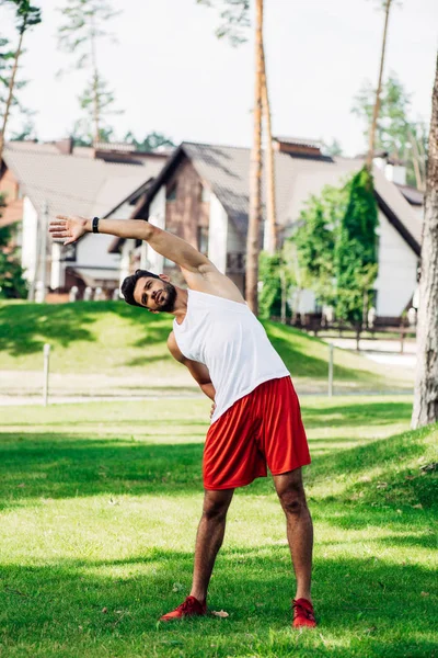 Desportista atlético barbudo trabalhando no gramado verde — Fotografia de Stock