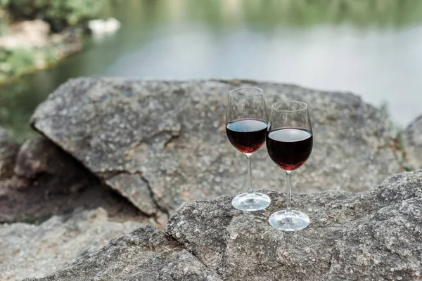 Enfoque selectivo de copas de vino con vino aromático tinto en piedra - foto de stock