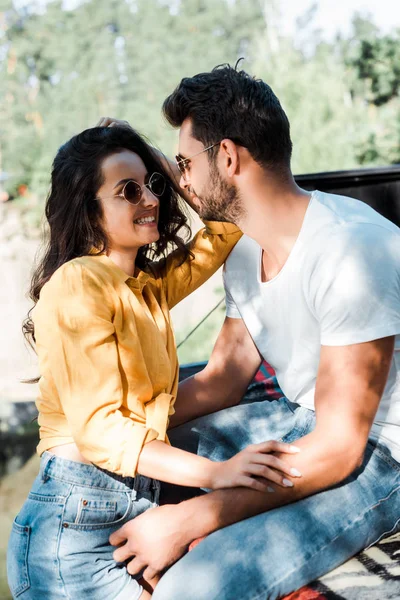 Fröhlicher bärtiger Mann blickt attraktive Frau mit Sonnenbrille an — Stockfoto