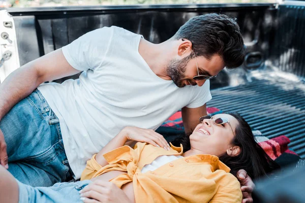 Schöner Mann schaut Frau an, die im Sommer auf Decke liegt — Stockfoto