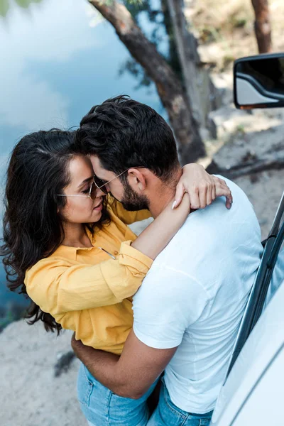 Overhead view of girl hugging boyfriend near automobile — Stock Photo