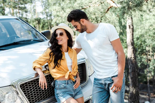 Uomo barbuto in occhiali da sole in piedi con donna in cappello di paglia — Foto stock