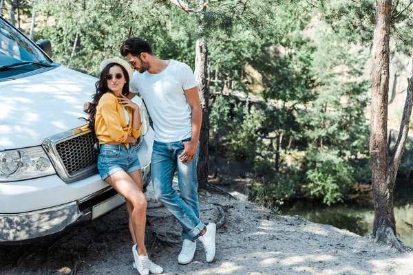 Hombre guapo mirando feliz elegante chica en sombrero de paja - foto de stock