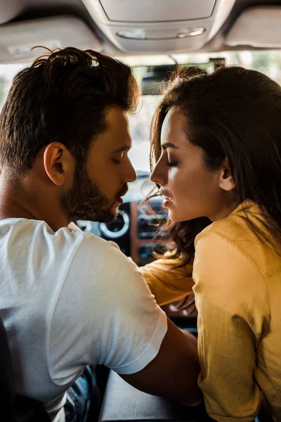 Vista lateral de homem bonito e mulher atraente com olhos fechados no carro — Fotografia de Stock