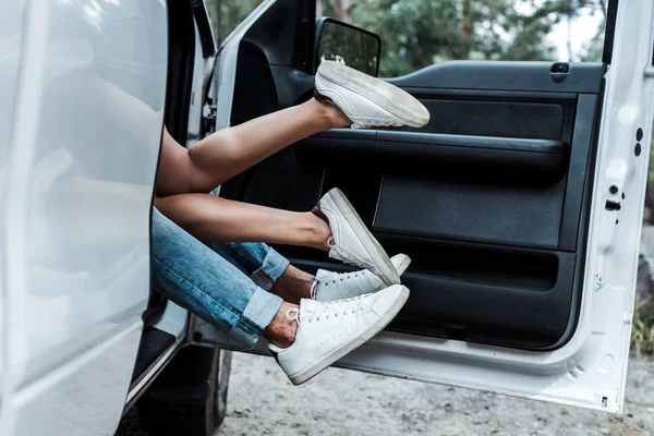 Corte vista de jovem homem e menina fazendo para fora no carro moderno — Fotografia de Stock