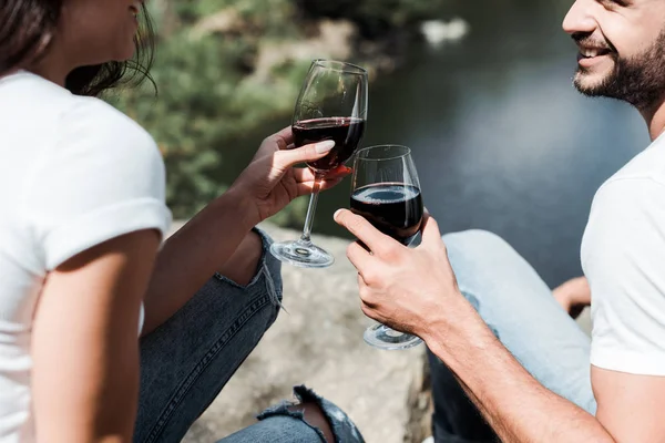 Vista cortada de homem e menina barbudo feliz segurando copos de vinho com vinho tinto — Fotografia de Stock