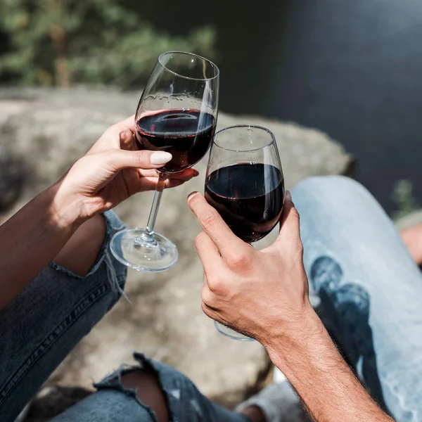 Vista cortada de homem e jovem mulher clinking copos de vinho — Fotografia de Stock