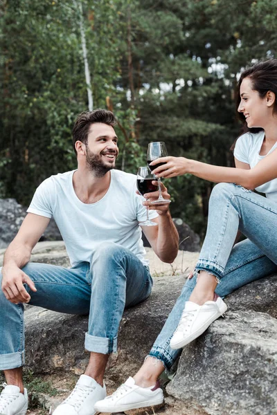 Glücklicher Mann und junge Frau klimpern mit Weingläsern — Stockfoto