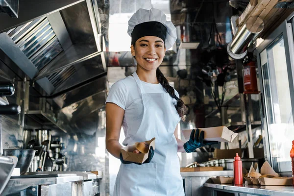 Feliz asiático chef segurando placas de papelão em comida caminhão — Fotografia de Stock