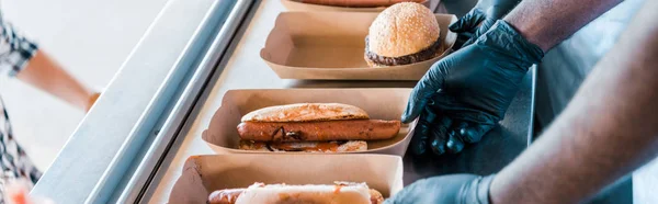 Tiro panorâmico de chefs multiculturais segurando placas de papelão com comida de rua — Fotografia de Stock