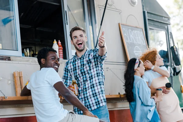 Foyer sélectif de beaux hommes gesticulant près d'amis et de filles afro-américaines — Photo de stock