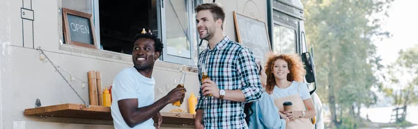 Panoramic shot of multicultural people near food truck — Stock Photo