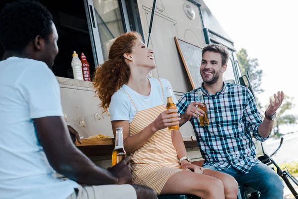 Selective focus of happy man gesturing near multicultural friends — Stock Photo