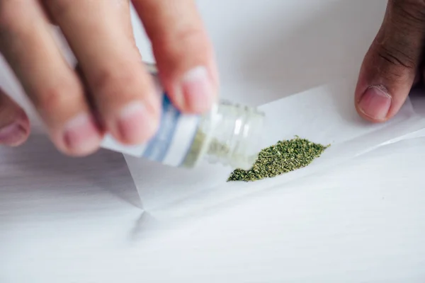 Cropped view of man in t-shirt pouring out medical cannabis — Stock Photo