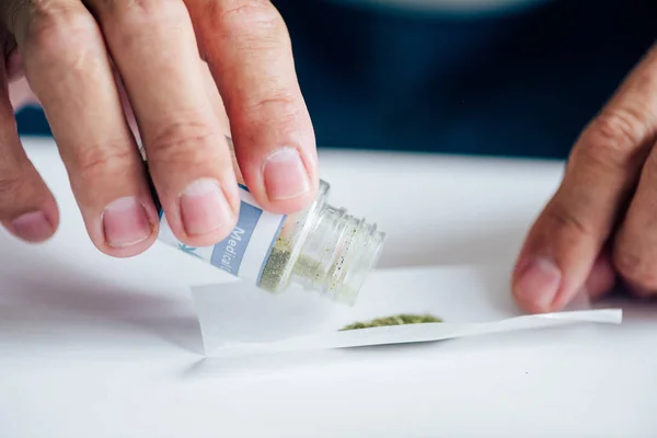 Cropped view of man in t-shirt pouring out medical cannabis — Stock Photo