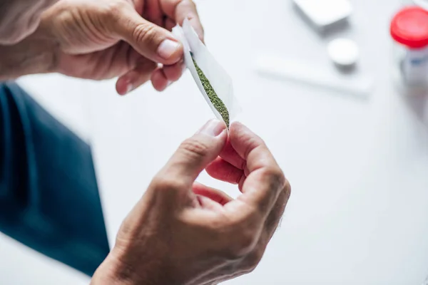 Ausgeschnittene Ansicht eines Mannes, der stumpf mit medizinischem Cannabis rollte — Stockfoto