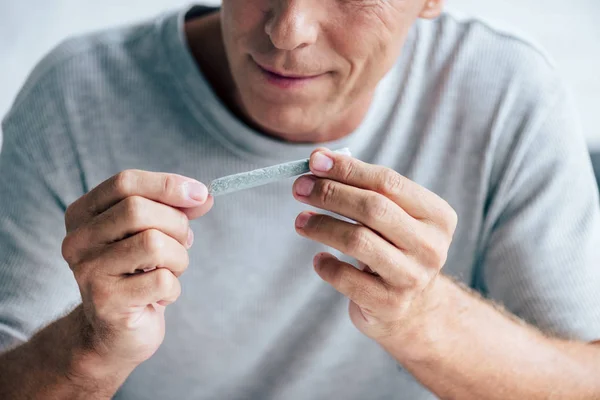 Visão cortada do homem rolando contundente com cannabis medicinal — Fotografia de Stock