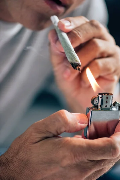 Cropped view of man lighting up blunt with medical cannabis — Stock Photo