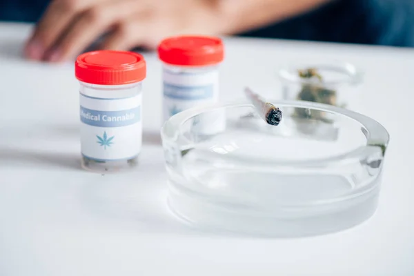 Selective focus of medical cannabis, blunt and ashtray on table — Stock Photo