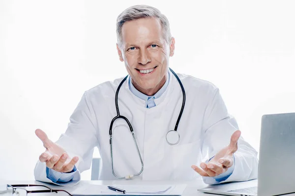 Guapo doctor en blanco abrigo sonriendo aislado en blanco - foto de stock