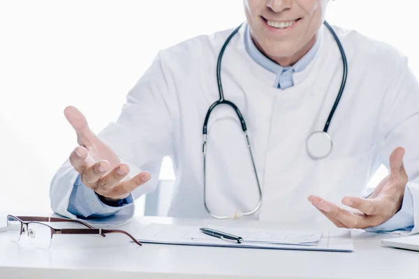 Vue recadrée du médecin en manteau blanc souriant isolé sur blanc — Photo de stock