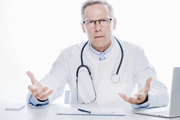 Handsome doctor in white coat looking at camera isolated on white — Stock Photo