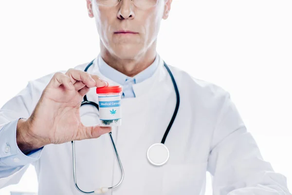 Cropped view of doctor in white coat holding medical cannabis isolated on white — Stock Photo
